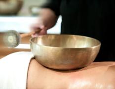 Impuls Hotel Tirol Ein Gast bei einer Klangschalenbehandlung im Wellnessbereich des Impuls Hotels Tirol