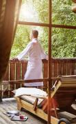 DAS RONACHER Thermal und Spa Resort Ein Mann steht am Balkon des Saunadorfes im DAS RONACHER Thermal und Spa Resort