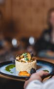 DAS WALCHSEE Sportresort Eine Servicekraft bringt ein Dessert im Restaurant des DAS WALCHSEE Sportresorts
