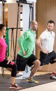 Das Hohe Salve Sportresort Zwei Gäste trainieren mit einem Personal Trainer im Fitnessbereich des Das Hohe Salve Sportresorts